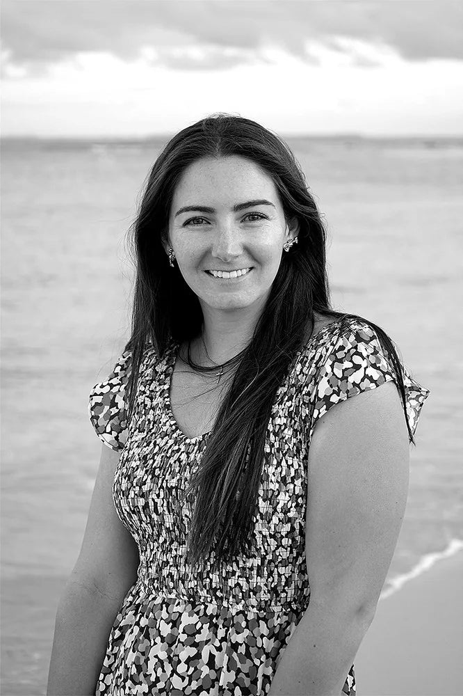 Julia B., founder and owner of Idlekind, in a black and white portrait on the beach